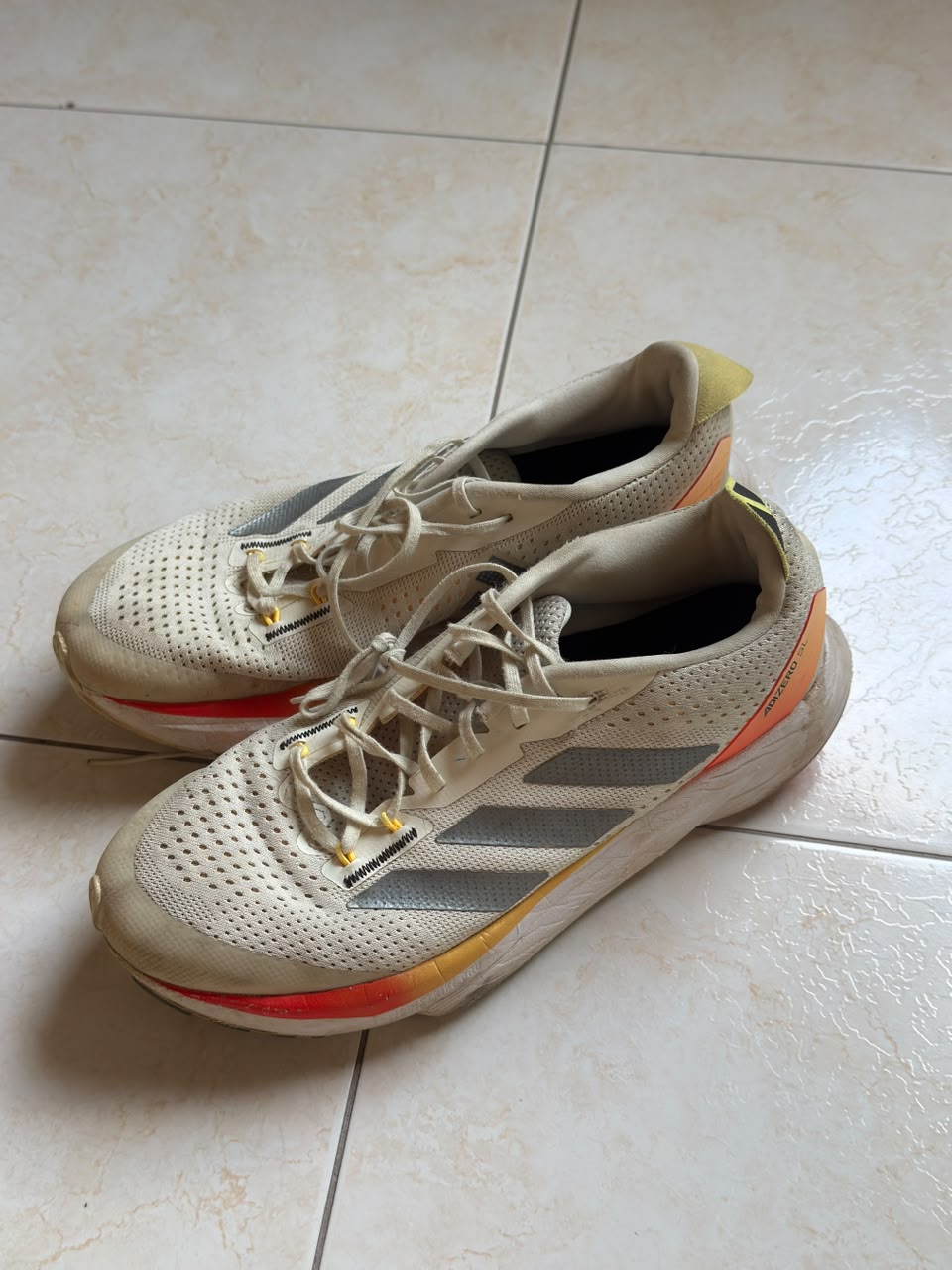 Tenis deportivos beige con detalles grises y naranjas